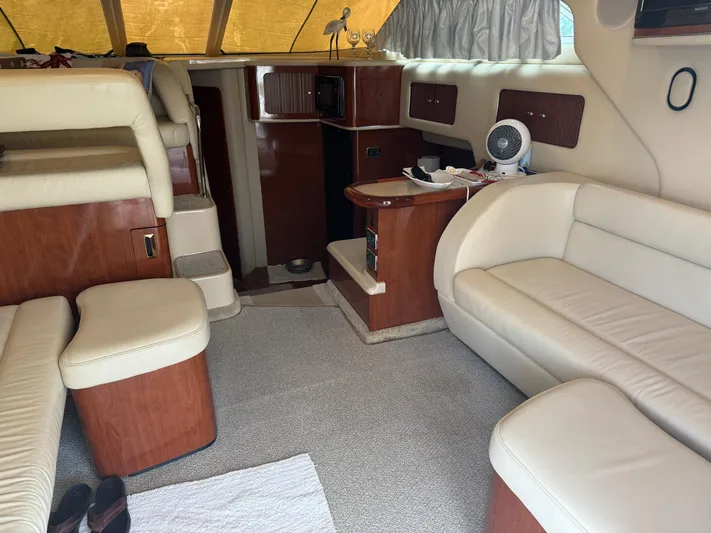 Messing About Yacht Photos Pics Interior of 2003 Sea Ray 400 Sedan Bridge with beige leather seating and wood accents.