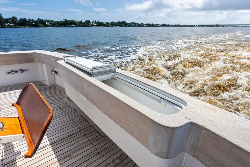 Sonny Boy Yacht Photos Pics 2004 Bertram 570 yacht deck with wooden seating, cruising on a sunny day.