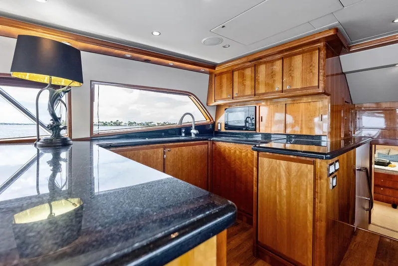 Sonny Boy Yacht Photos Pics Luxurious kitchen interior of 2004 Bertram 570 yacht with wooden cabinetry and modern appliances.
