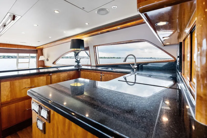 Sonny Boy Yacht Photos Pics Luxurious kitchen interior of a 2004 Bertram 570 yacht with sleek countertops and elegant wood finishes.