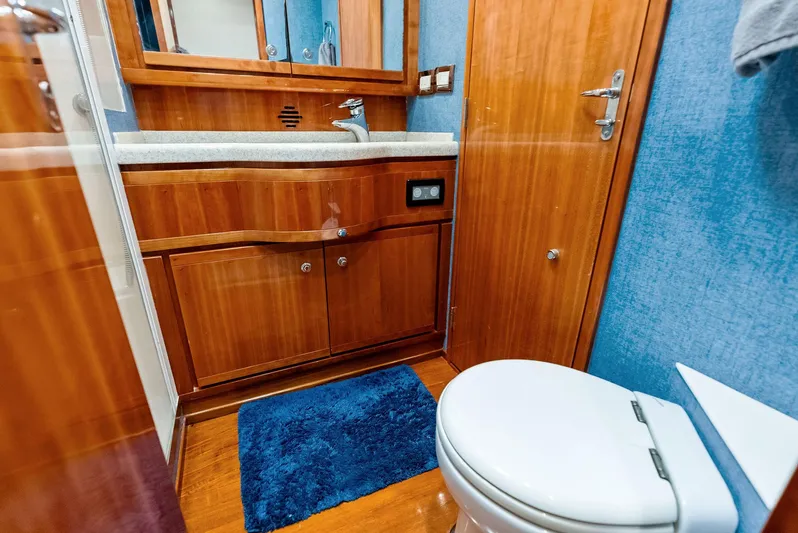 Sonny Boy Yacht Photos Pics Luxurious 2004 Bertram 570 yacht bathroom with wooden cabinetry and modern fixtures.