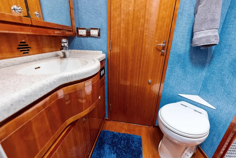 Sonny Boy Yacht Photos Pics Luxurious bathroom interior of a 2004 Bertram 570 yacht with wooden cabinetry and modern fixtures.