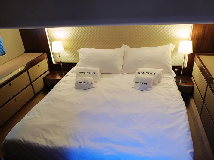  Yacht Photos Pics Luxurious bedroom in 2025 Fairline Squadron 50 yacht with elegant lighting and branded towels.