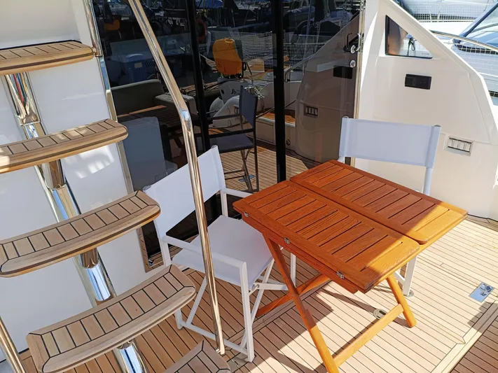  Yacht Photos Pics 2025 Fairline Squadron 50 yacht deck with wooden table and chairs.