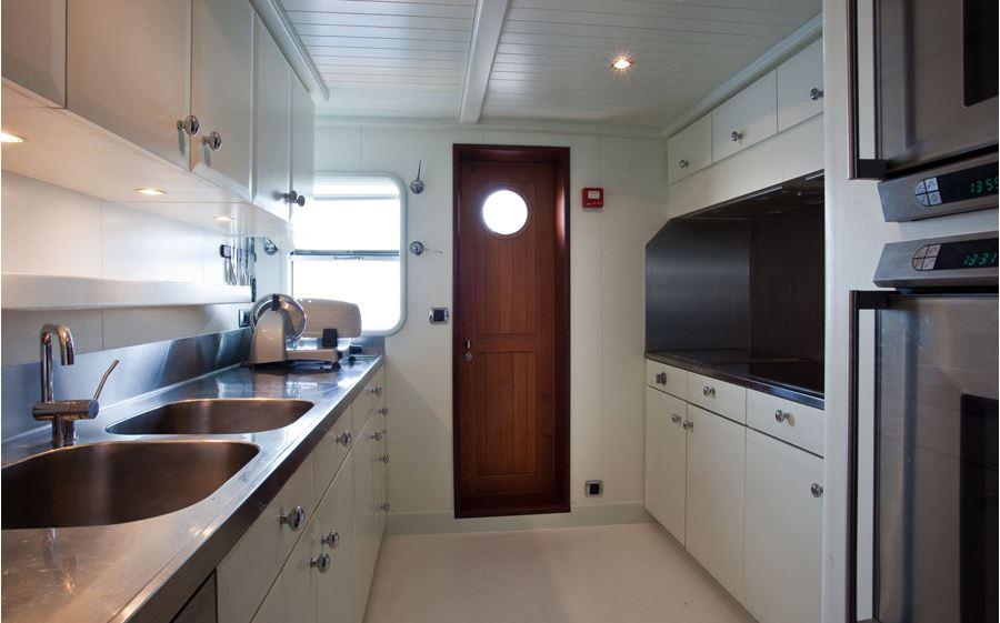 Luxurious kitchen interior on 2005 Explorer Trawler 33m yacht, featuring modern appliances and sleek design.