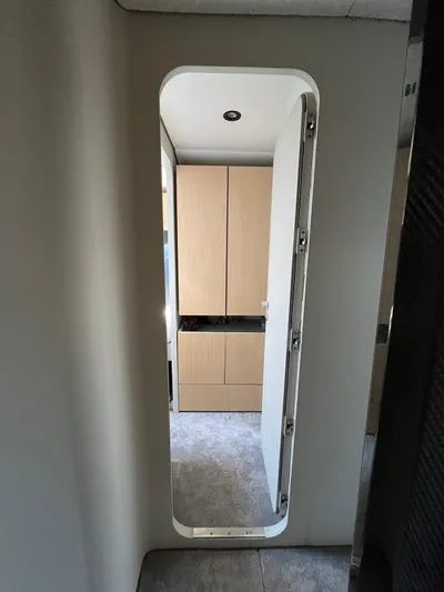  Yacht Photos Pics Interior view of a 2004 Vismara V78 yacht, featuring a modern doorway and wooden cabinetry.