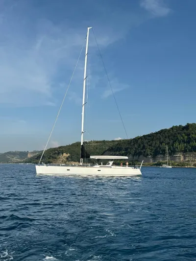  Yacht Photos Pics Sailing yacht Vismara V78, 2004 model, cruising on calm waters near a scenic coastline.
