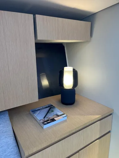  Yacht Photos Pics Modern interior of Vismara V78 yacht with lamp and book on wooden cabinet, 2004 model.