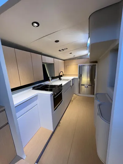  Yacht Photos Pics Modern kitchen interior of 2004 Vismara V78 yacht with sleek cabinetry and stainless steel appliances.