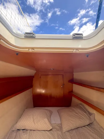  Yacht Photos Pics Cabin interior of 2006 Fountaine Pajot Bahia 46 catamaran with cozy bedding and wooden shelves.
