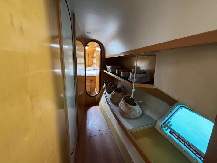  Yacht Photos Pics Interior hallway of 2006 Fountaine Pajot Bahia 46 catamaran with storage shelves and window.