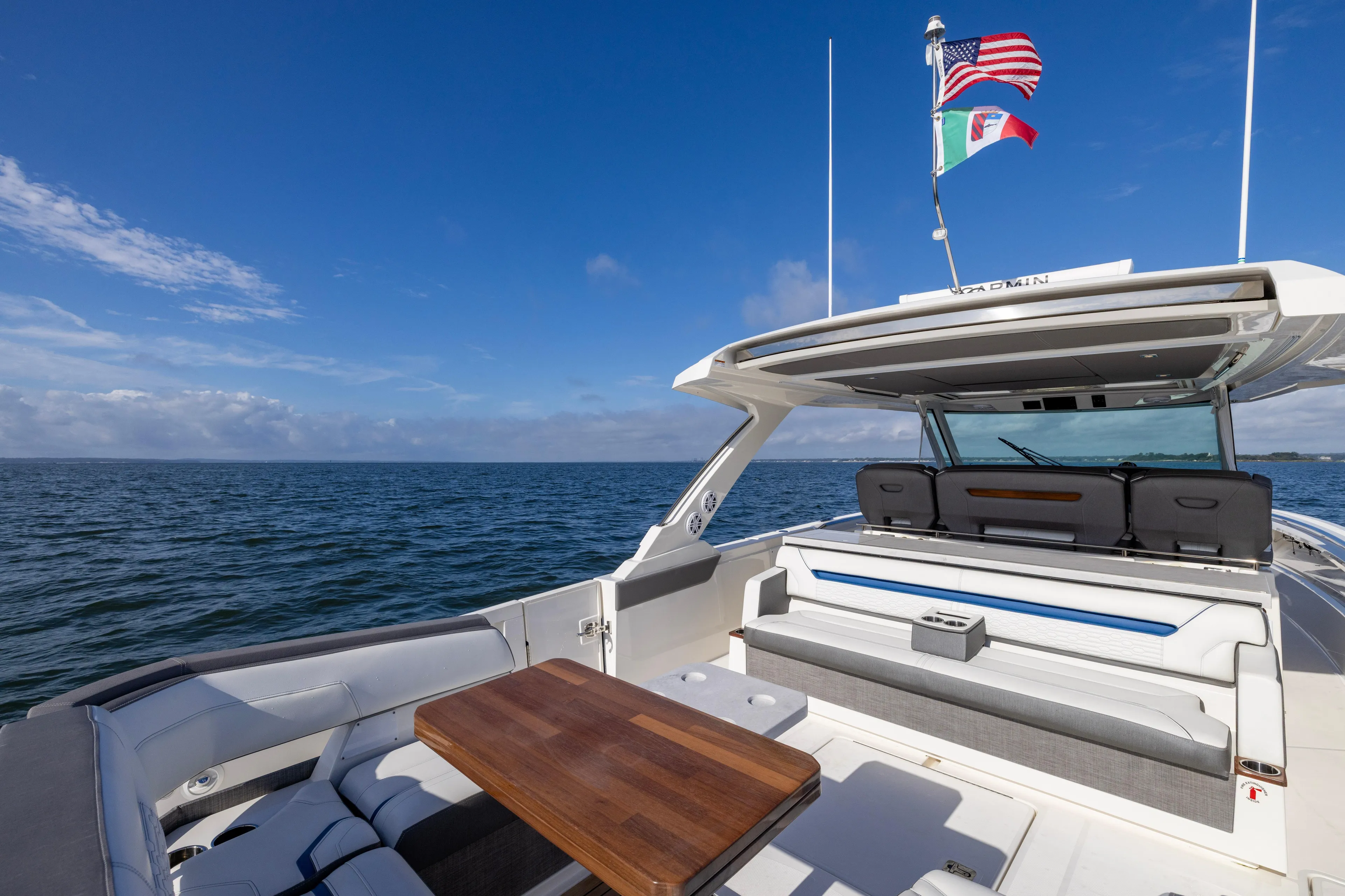 Princess Gia Yacht Photos Pics 2021 Tiara Yachts 43 LS, luxury deck view, ocean backdrop, flags waving, clear blue sky.