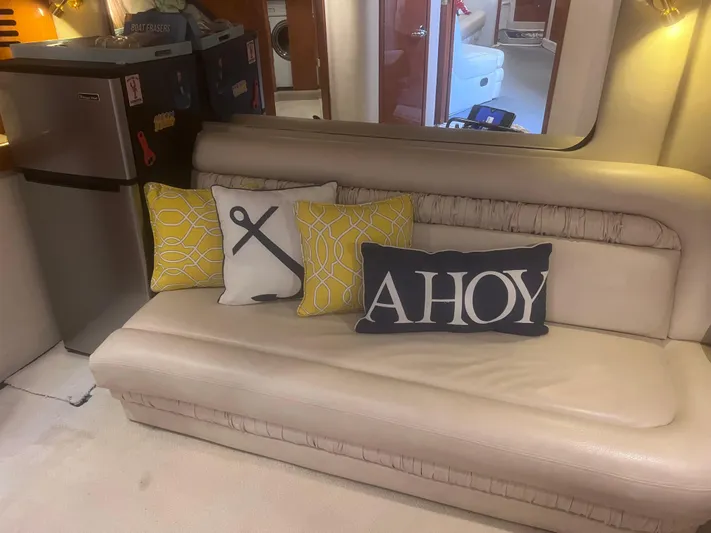 Phantom Yacht Photos Pics Interior of 2000 Sea Ray 460 Sundancer with nautical-themed cushions on a beige sofa.