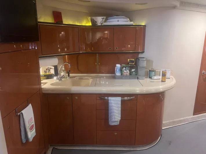 Phantom Yacht Photos Pics Luxurious kitchen interior of 2000 Sea Ray 460 Sundancer yacht with wooden cabinetry.