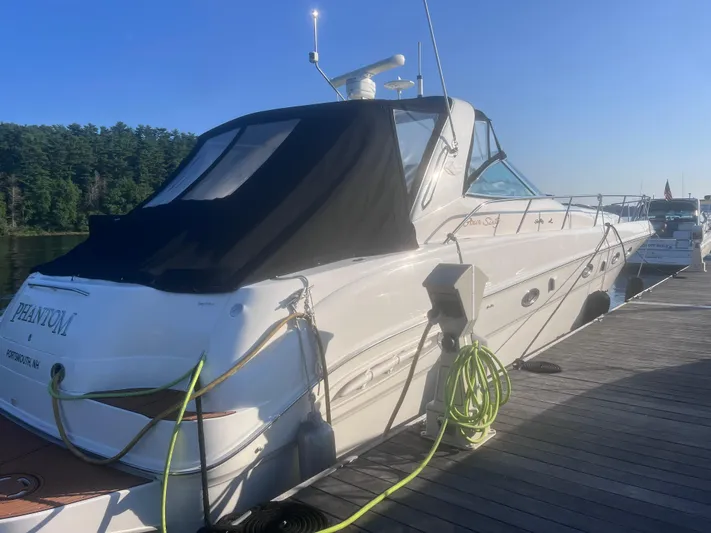 Phantom Yacht Photos Pics 2000 Sea Ray 460 Sundancer yacht docked with black canopy and green hose.