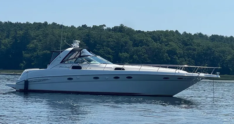 Phantom Yacht Photos Pics 2000 Sea Ray 460 Sundancer yacht on calm water with forested background.