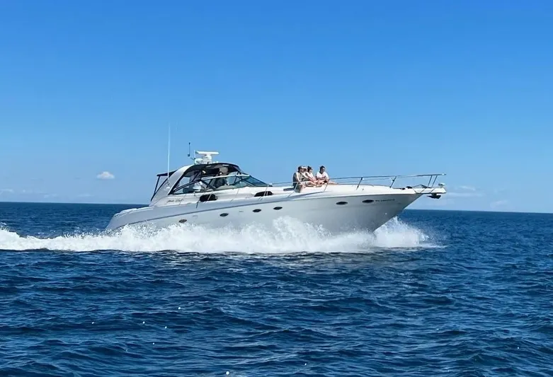 Phantom Yacht Photos Pics 2000 Sea Ray 460 Sundancer cruising on open water under clear blue sky.
