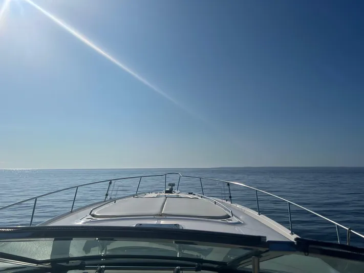 Phantom Yacht Photos Pics Bow view of 2000 Sea Ray 460 Sundancer yacht cruising on calm ocean under clear blue sky.