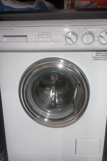 Phantom Yacht Photos Pics Front-loading washing machine with control dials and a metallic door.