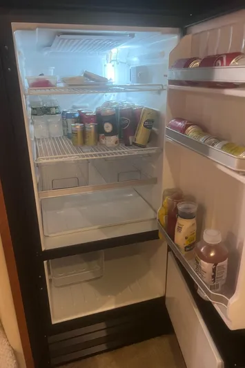 Phantom Yacht Photos Pics Open refrigerator inside a 2000 Sea Ray 460 Sundancer yacht, stocked with various beverages and condiments.