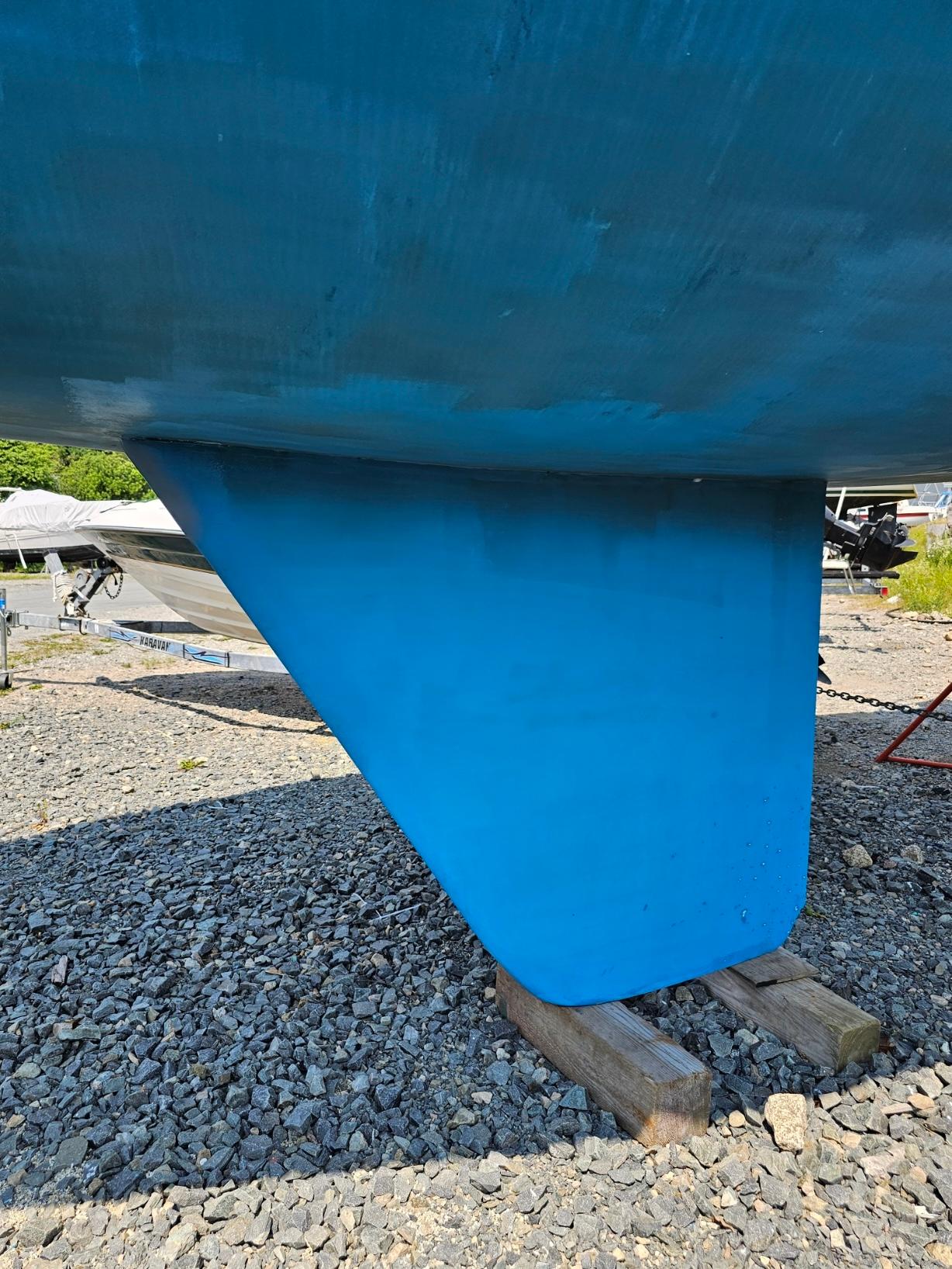 1987 CS 30 sailboat keel on gravel, supported by wooden blocks.