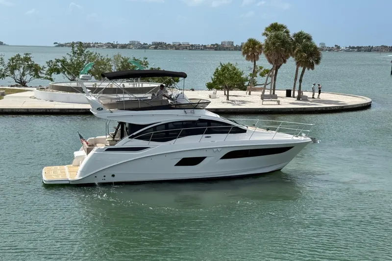 Tea Time III Yacht Photos Pics 2018 Sea Ray Fly 400 yacht cruising in a scenic coastal area with palm trees.