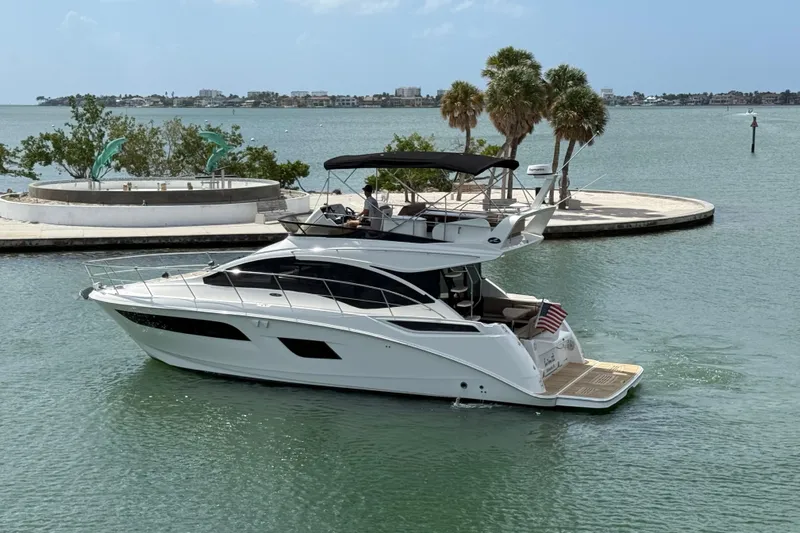 Tea Time III Yacht Photos Pics 2018 Sea Ray Fly 400 yacht cruising near a scenic waterfront with palm trees.