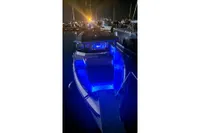 2024 Saxdor 320 GTC boat illuminated with blue lights at night in a marina.