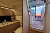Luxurious interior of 2024 Saxdor 320 GTC boat, featuring modern bathroom and cockpit view.