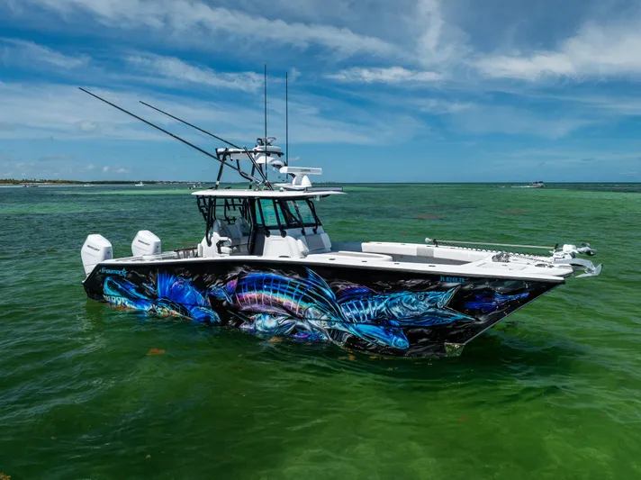  Yacht Photos Pics 2025 Freeman 34 VH boat with vibrant marine artwork, cruising in clear green waters.