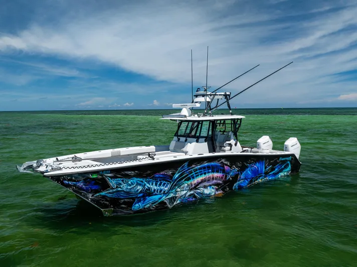 Yacht Photos Pics 2025 Freeman 34 VH boat with vibrant marine artwork, floating on clear green water.