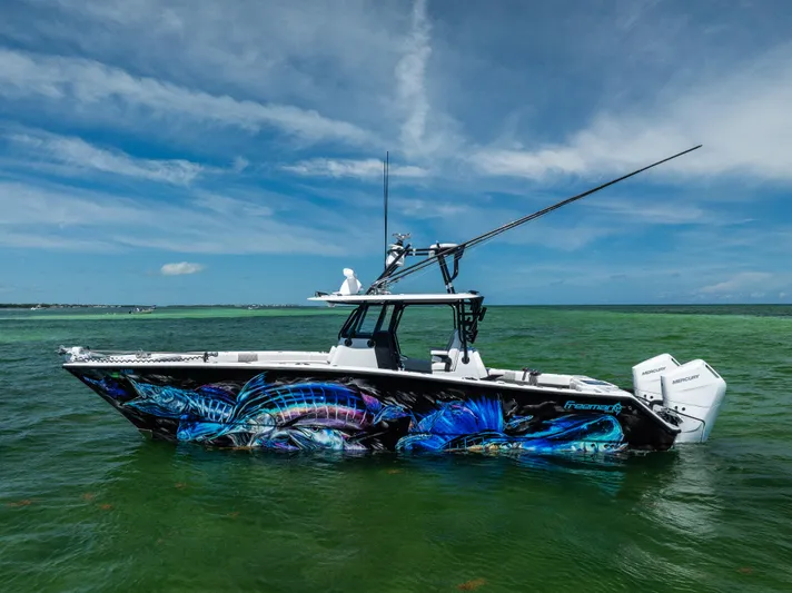  Yacht Photos Pics 2025 Freeman 34 VH boat with vibrant marine artwork, cruising on clear green waters.