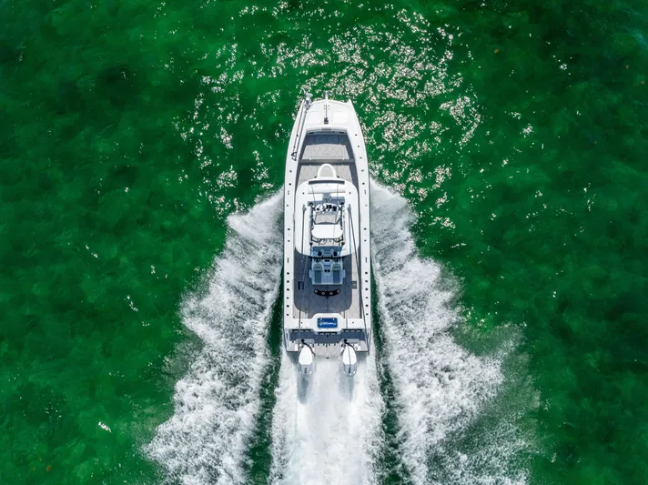  Yacht Photos Pics Aerial view of 2025 Freeman 34 VH boat cruising on vibrant green water.