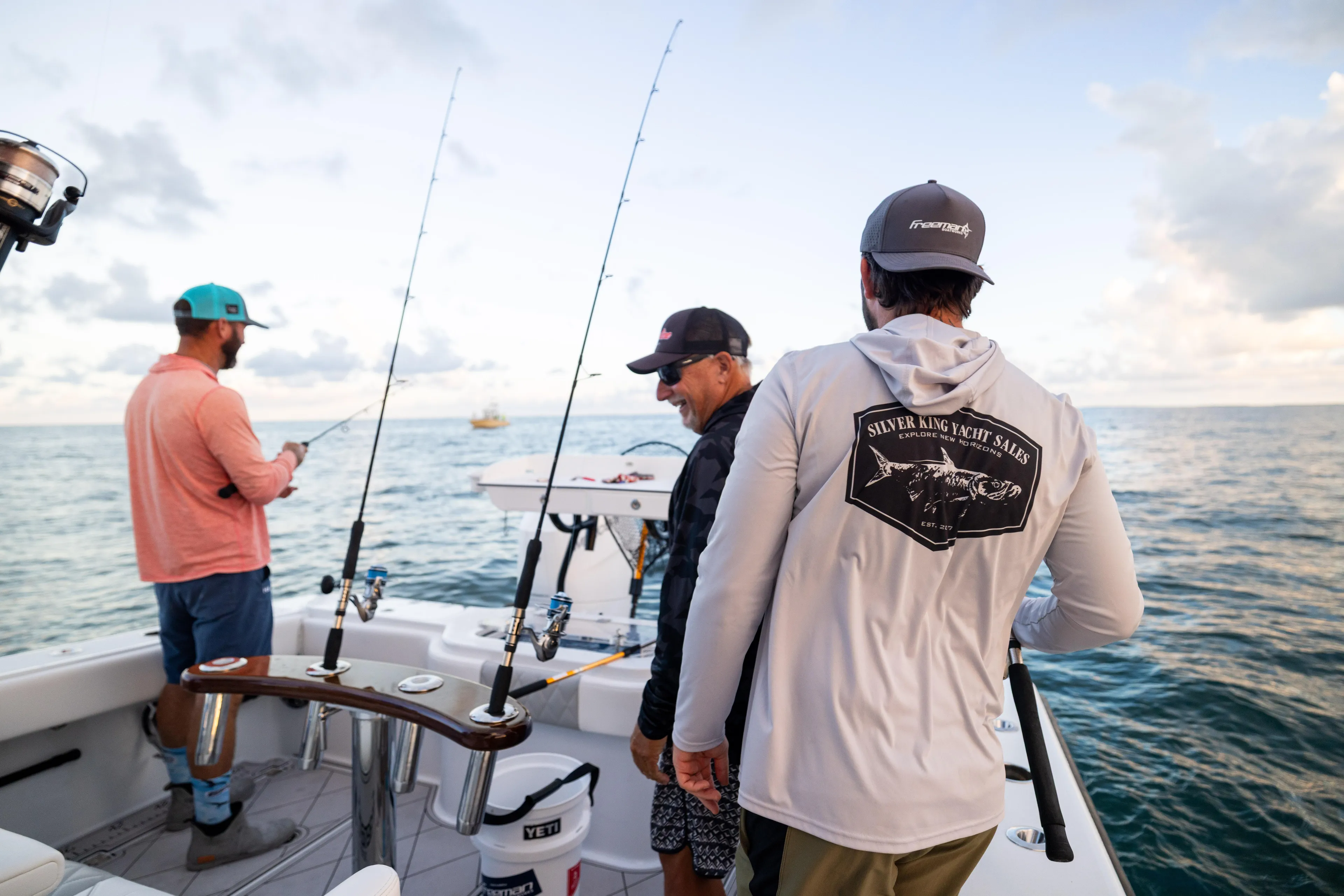  Yacht Photos Pics Men fishing on a 2025 Freeman 34 VH boat, enjoying a sunny day at sea.