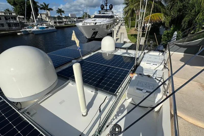 Talon Yacht Photos Pics 2011 Sunreef 62 yacht with solar panels docked by waterfront homes.