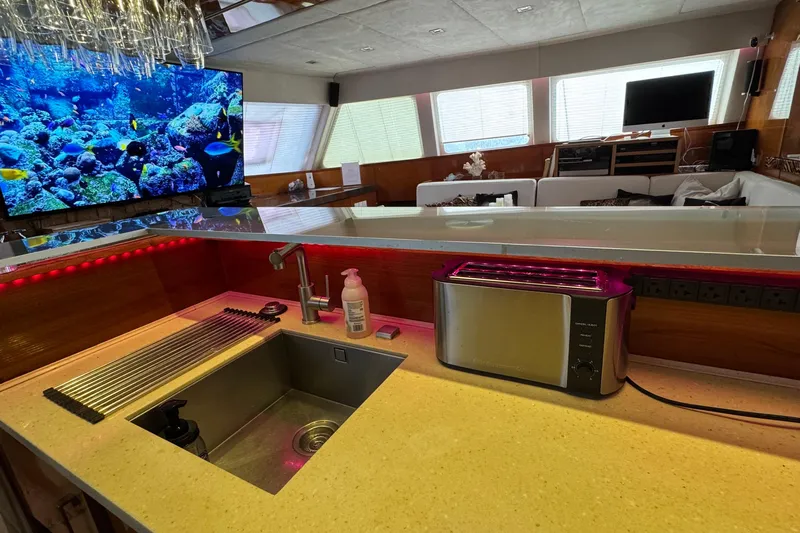 Talon Yacht Photos Pics Luxurious Sunreef 62 yacht interior with modern kitchen, sink, toaster, and vibrant aquarium display.
