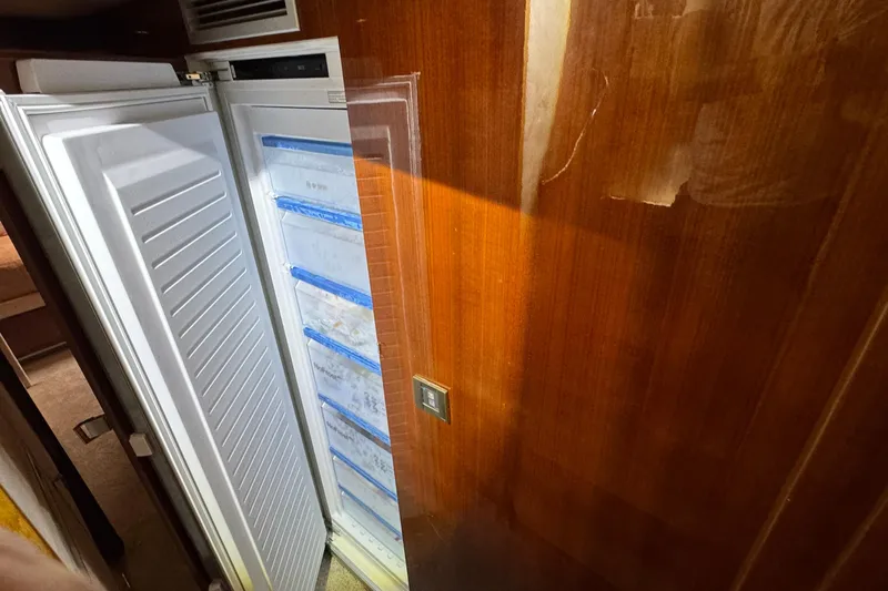 Talon Yacht Photos Pics Open refrigerator on 2011 Sunreef 62 yacht, wooden interior, showing organized storage.