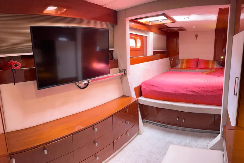 Talon Yacht Photos Pics Luxurious 2011 Sunreef 62 yacht bedroom with TV, wooden cabinetry, and cozy bed.