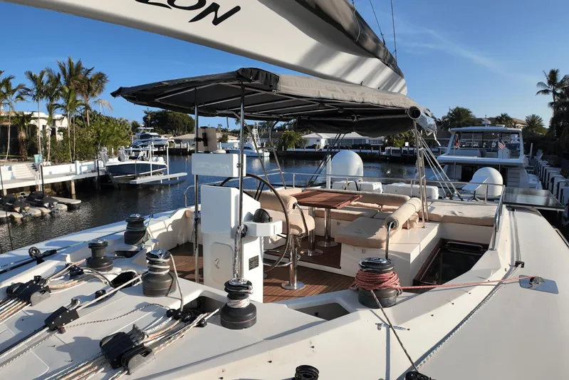 Talon Yacht Photos Pics 2011 Sunreef 62 yacht with spacious deck and seating area, docked in a marina.