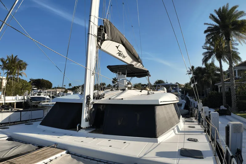 Talon Yacht Photos Pics 2011 Sunreef 62 yacht docked, surrounded by palm trees and clear blue sky.