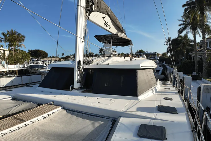 Talon Yacht Photos Pics 2011 Sunreef 62 yacht docked, featuring sleek design and spacious deck, surrounded by palm trees.