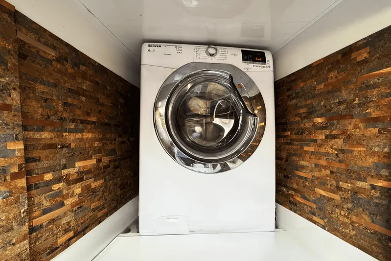 Talon Yacht Photos Pics Washing machine in a Sunreef 62 yacht, 2011 model, with textured brown walls.