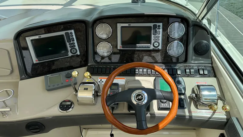 Yacht Photos Pics Helm of 2006 Sea Ray 44 Sundancer with wood steering wheel and navigation instruments.
