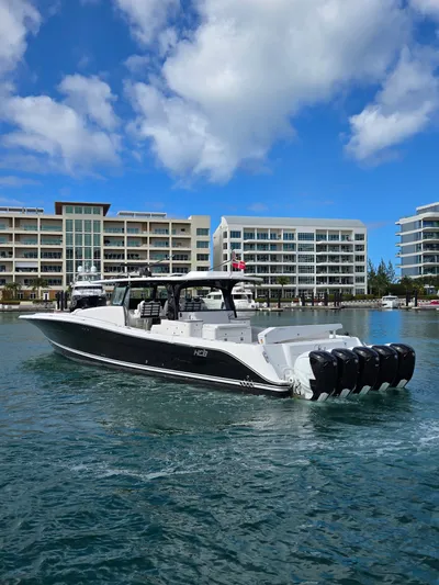 Lady Mash Yacht Photos Pics 2021 HCB 65 Estrella boat on water, modern buildings in background, clear blue sky.