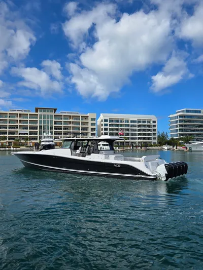 Lady Mash Yacht Photos Pics 2021 HCB 65 Estrella boat on water with modern buildings in background.