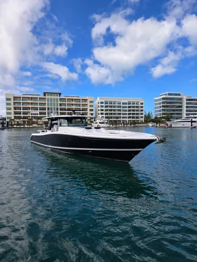 Lady Mash Yacht Photos Pics 2021 HCB 65 Estrella boat on water with modern buildings in background.