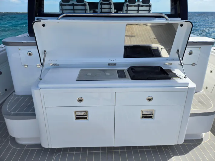 Lady Mash Yacht Photos Pics 2021 HCB 65 Estrella boat kitchen with stove and storage, ocean view in background.