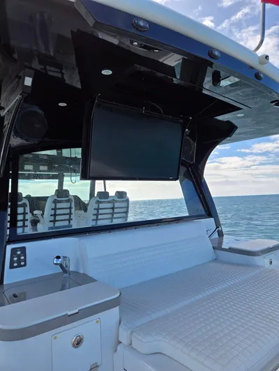 Lady Mash Yacht Photos Pics 2021 HCB 65 Estrella yacht interior with seating, TV, and ocean view.