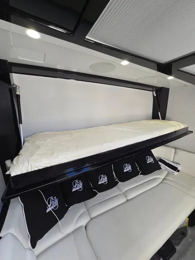 Lady Mash Yacht Photos Pics Interior of 2021 HCB 65 Estrella with a fold-down bed and cushioned seating.