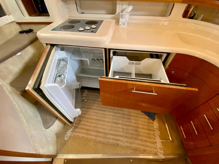  Yacht Photos Pics Interior of a 1996 Sea Ray 450 Sundancer showing kitchen with open fridge and drawers.